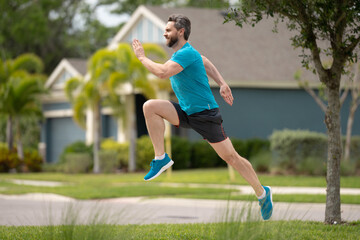 Sport runner. Man running. Fit male sport fitness model sprinting outdoors. Attractive man running fast, workout outdoors, runner jogging over american street.