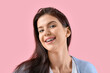 Young woman with dental braces on pink background, closeup