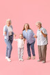 © Pixel-Shot - Little girl with her family holding hands on pink background