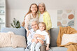 © Pixel-Shot - Little girl with her family sitting on sofa at home