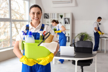 Canvas Print - Female janitor with bucket of cleaning supplies in office