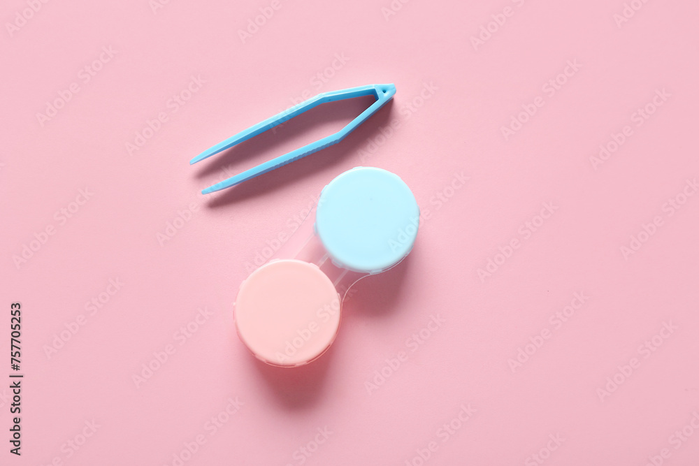Container for contact lenses with tweezers on pink background