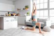 © Pixel-Shot - Sporty pregnant woman training on fitness mat in kitchen