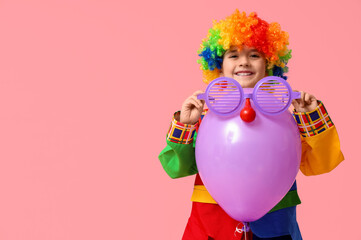 Poster - Cute little boy in clown costume with funny glasses and balloon on pink background. April Fools Day celebration