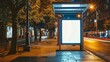 Empty vertical digital billboard at a city street bus stop during the night, ideal for showcasing advertisements or promotional content in an urban setting