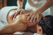 Masseur doing back massage for young woman using Tapotement technique to relieve muscle tension