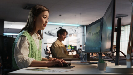Fototapete - Asian Woman Using Desktop Computer And Designing In 3D Modelling Software Unique World And Characters For Survival Video Game In Diverse Office. Female Game Developer Creating Immersive Gameplay