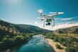 A white drone is flying over a river with a green