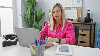 Sticker - A young woman in a pink shirt works at her office desk with a laptop and smartphone, expressing various emotions.