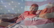 Image of flag of united states of america over senior biracial couple in deckchairs on beach