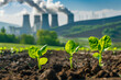 Young plants sprouting from the earth with a nuclear power plant emitting smoke in the background, illustrating the contrast between nature and industrial impact