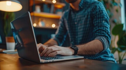 Wall Mural - Young man working on laptop computer at home office. Male hands typing on keyboard