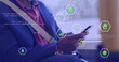 Image of data processing with icons over african american businessman using smartphone in bus
