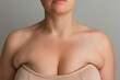 A woman with a large bust is wearing a white bra
