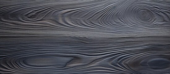 Poster - A close up of a black wood grain pattern with a liquidlike texture resembling an aeolian landform. The deep grey and electric blue hues give it a unique landscape flooring design