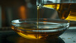 Olive oil pours steadily from a bottle into a glass bowl, creating a smooth stream