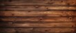 A close up of a brown hardwood plank flooring with a wood stain, creating a beautiful pattern of rectangles. The background is blurred to highlight the details of the wood
