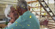 Image of gold confetti falling over happy caucasian senior couple dancing at home