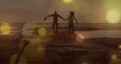 Yellow spots of light over african american couple holding hands walking on the rocks near the sea