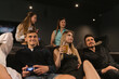 © SlavaStock - Focused students delve in virtual realms on screen. Group of friends immerse in dynamic tapestry of gaming experiences during party