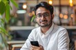 Portrait of young indian programmer businessman, man in glasses holding phone, looking at camera and smiling, happy with achievement results freelancer, Generative AI