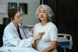 © NINENII - Doctor with stethoscope examining elderly patient with examination, presenting symptoms and recommending treatment, healthcare and medical concept.