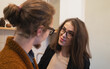 © DedMityay - Smiling woman with glasses warmly looking at her partner, creating heartfelt and comfortable indoor atmosphere.