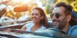 © tashechka - Cheerful man and woman enjoying a sunny day in a convertible car, laughter and fun abound.