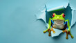 A vibrant green frog with striking red eyes emerges from a tear in a blue paper, symbolizing surprise and discovery