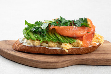 Wall Mural - Breakfast toast with salmon and avocado on wooden board