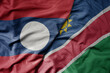 big waving national colorful flag of namibia and national flag of laos.