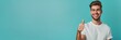 © Funk Design - Joyful Young Man Giving Thumbs Up in Casual Shirt on solid, bright turquoise color background