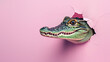 Close-up of an alligator head breaking through a pink wall implying fearlessness and boldness