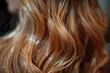 A detailed image capturing the texture and shine of curled strands of orange hair with sparkling droplets