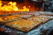 Freshly baked golden pastries gleam as they travel through the fiery heat of an industrial oven