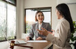 © wichayada - A young lawyer and businesswoman are discussing legal advice on signing a business contract. Insurance or financial contract signing
