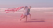 Image of smiling caucasian siblings with american flags running at beach