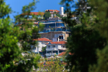 Wall Mural - Southern cityscape, view of buildings and houses, palm trees and mountains, in public places in Turkey, sunny summer day in a resort town