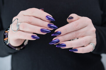 Wall Mural - Female hand with long nails and purple blue ink manicure