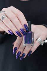 Wall Mural - Female hand with long nails and purple blue ink manicure