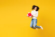 Full body little kid teen girl of African American ethnicity wear white casual clothes jump high hold present box with gift ribbon bow isolated on plain yellow background. Childhood lifestyle concept.