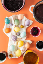 The Process Of Dyeing Easter Eggs With Natural Dyes, Hibiscus And Turmeric, Onion Peel And Red Cabbage, Beetroot Juice, Paint Containers And Colored Eggs On A Napkin