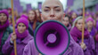 Thousands of people march in the city streets. Women rights protesters. Bald woman with purple loudspeaker.