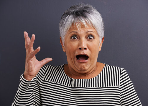 Shock, portrait and senior woman in studio with fear, scared and terror facial expression. Surprise, crazy and elderly female person with terrified or horror face isolated by black background.