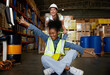 © offsuperphoto - factory workers moving cart and having fun in the warehouse storage