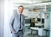 © peopleimages.com - Confident, portrait and man in conference room at office for business as realtor in London with happiness. Professional, entrepreneur or expert real estate agent for development in corporate property