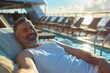 Senior man with a cheerful expression, lounging on a plush sunbed by the pool onboard a cruise ship