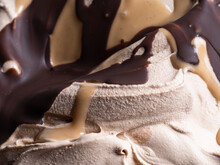 Frozen Toffifee flavour gelato - full frame detail. Close up of beige creamy surface texture of Ice cream covered with caramel and chocolate topping.