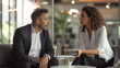 © Studio Nova - Two professionals in smart casual attire are engaged in a serious consultation at the office, with one holding papers and attentively discussing with the other.