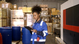 Fototapeta Paryż - Female worker counting goods in warehouse